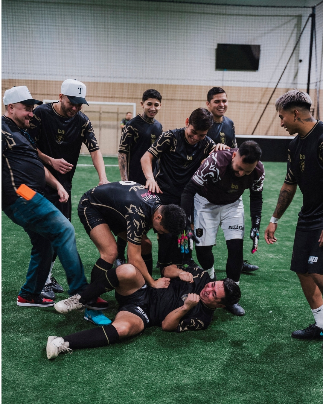 ba Gear custom soccer team celebrating and having fun on indoor field wearing black uniforms